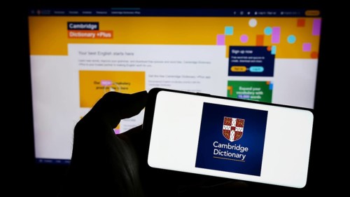 Stuttgart, Germany, 07-11-2023: Person holding cellphone with logo of Cambridge Dictionary on