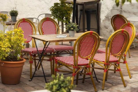 Outdoor empty coffee and restaurant terrace with red and white chairs and table, flowers