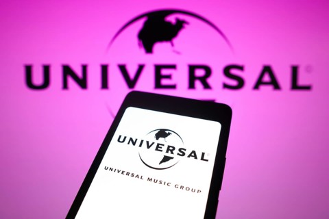 In this photo illustration, the Universal Music Group logo is displayed on a smartphone screen and