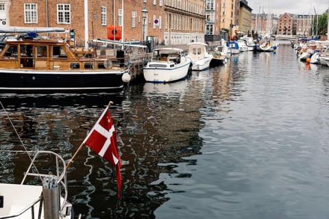 Copenhagen, Denmark, August 12, 2016: Port of Copenhagen with boats and ships moored. Danish flag