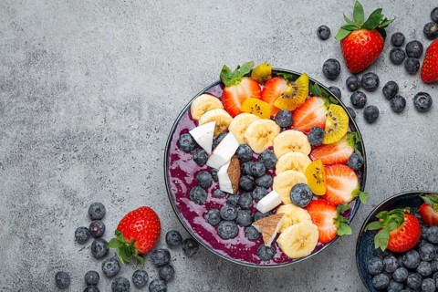Healthy summer acai smoothie bowl with chia seeds, fresh banana, strawberry, blueberry, cocos, kiwi