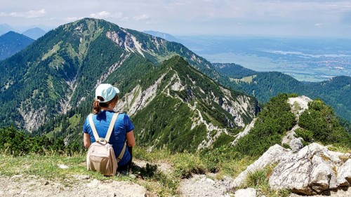 Hiker looks from Herzogstand to the ridge path to Heimgarten