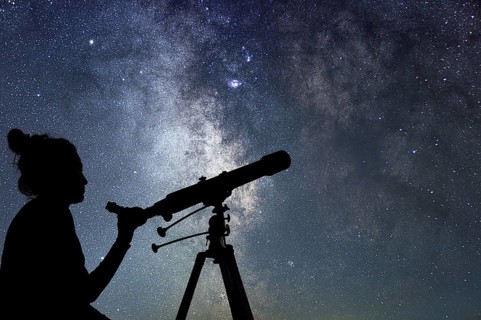 Woman with telescope watching the stars. Stargazing woman