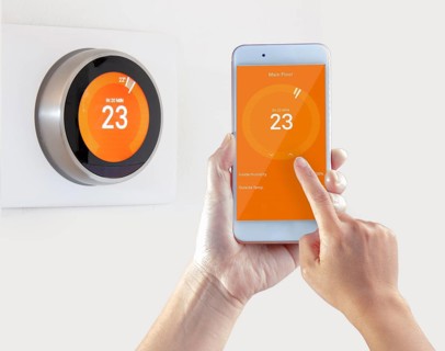 Smart Thermostat and a person setting up the temperature smart device hand hold on a white