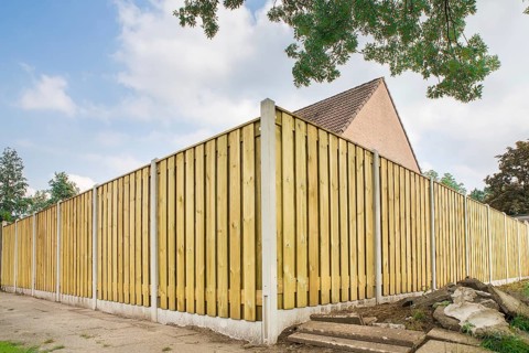 New wooden fence as corner around garden of home