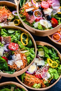 Round paper boxes with pre-packaged vegetable salads ready for sale
