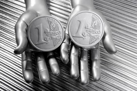 Two silver euro coins in futuristic robot gray metallic hands bank metaphor