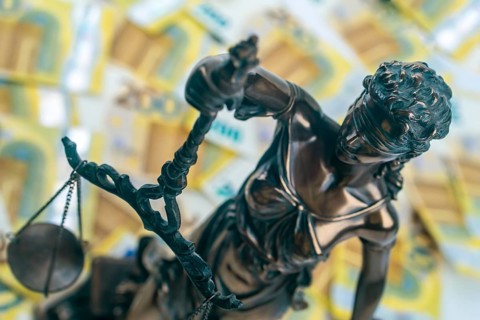Justitia Figure with 200 euro bills in the Background. Concept justice and money