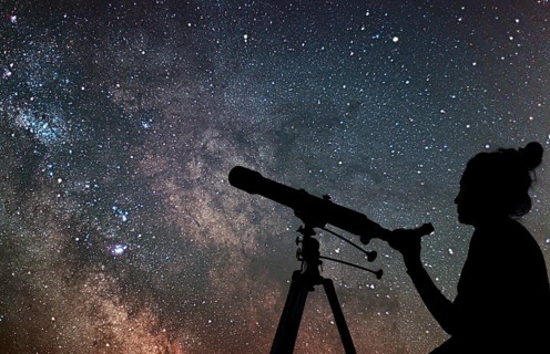 Woman with telescope watching the stars. Stargazing woman and night sky