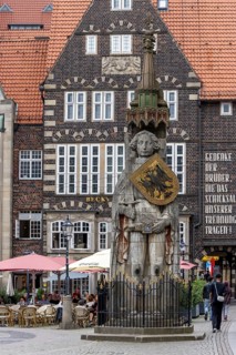 Stone statue with armour and coat of arms Bremen Roland on the market square in the old town of