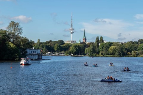 Leisure activities in summer, pedal boats and Alster-Touristik barge Susebek in front of a blue sky