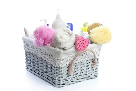 Bath toiletries basket with shower gel shampoo sponge and towel