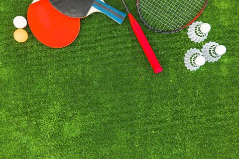 Ping pong balls shuttlecocks badminton rackets green turf