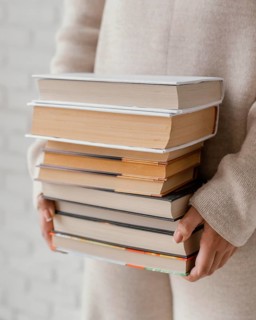 Close up hands holding books stack