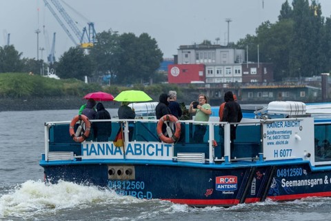 Symbolic picture weather, heavy rain in summer, thunderstorm, storm, tourists with umbrellas in the
