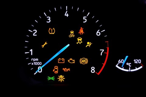 A car's dashboard lights up with multiple alert icons, signaling various vehicle functions and