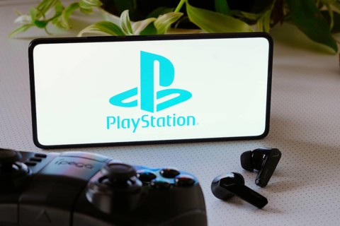 In this photo illustration, the PlayStation logo is displayed on a smartphone screen, next to a
