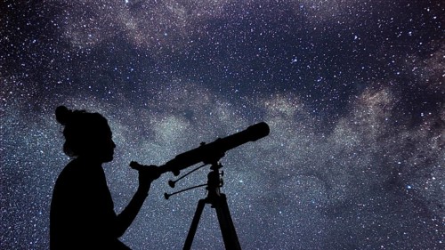 Woman with telescope watching the stars. Stargazing woman and night sky