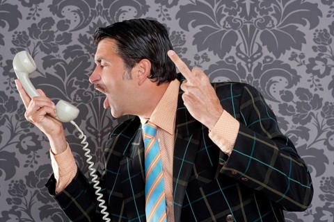 Businessman shouting angry expression and rude finger talking by telephone with retro mustache