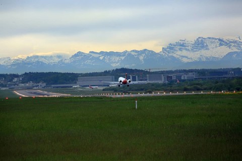 Landing of a Fokker 100 at Zurich Airport. View of the Swiss Alps