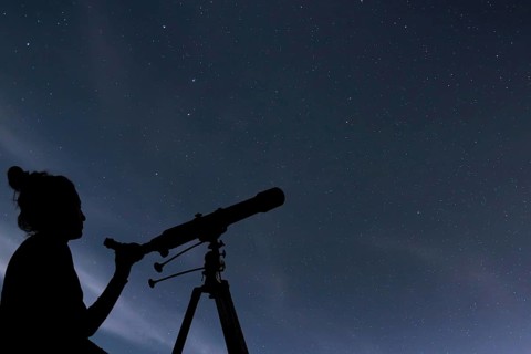Woman with telescope watching the stars. Stargazing woman and night sky