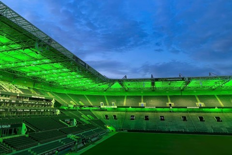Football stadium Borussiapark without spectators, illuminated in green, sunset, Mönchengladbach,