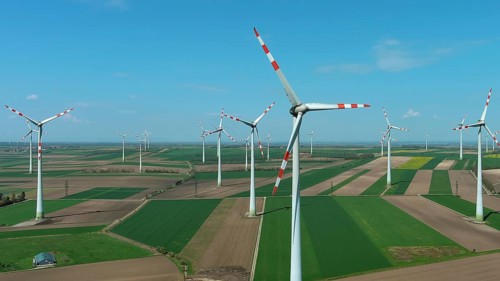 Aerial view of wind turbines and agriculture fields. Windmills turbines generating electricity,