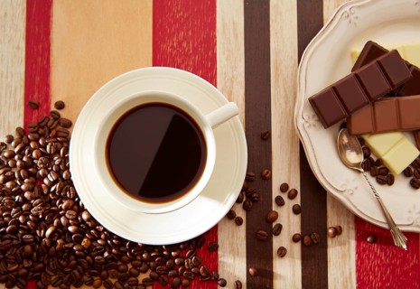 Coffee cup breakfast with chocolate and coffee beans on red brown wooden table