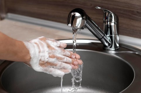 Side view woman washing hands sink