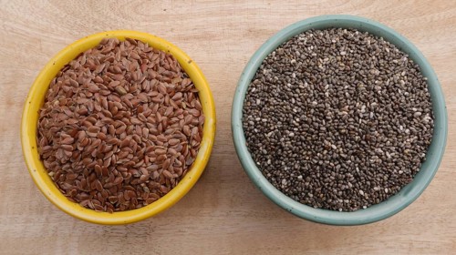 Chia Seeds (Salvia hispanica) vs Flaxseeds (linseeds) in Bowls on Wooden Background, Flat Lay Photo