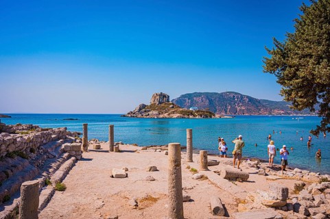 Ancient ruins on the shore with a view of the sea and a rocky island in the background, Agios