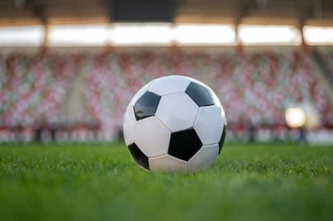 Soccer ball and legs of young player before kicking the ball