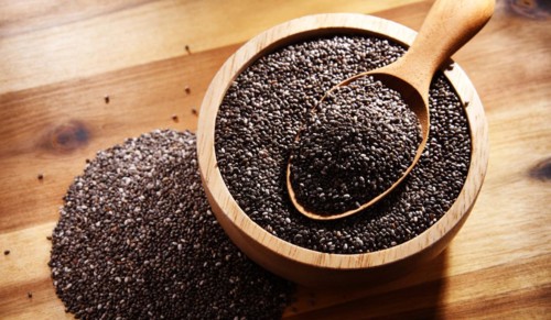 Bowl of chia seeds on wooden table