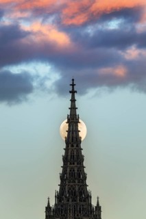 Full moon behind the minster of Ulm at sunset