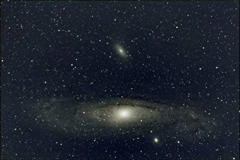 An impressive close-up of a large spiral galaxy (M 31, Andromeda Nebula) surrounded by countless