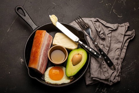 Main keto foods as butter, olive oil, fried egg, avocado, fat meat bacon for ketogenic diet on