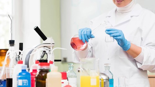 Close up scientist holding flask
