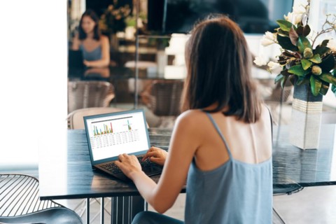Back view of young businesswoman working on laptop at modern home. freelance concept