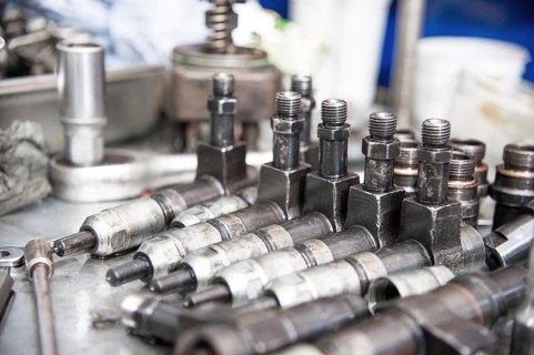 The old diesel injectors lie on the table in the fuel shop. The concept of repair of fuel diesel