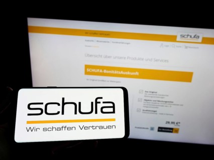 Stuttgart, Germany, 02-13-2022: Person holding mobile phone with logo of German credit protection