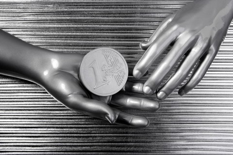 Silver euro coins in futuristic robot gray metallic hands bank metaphor