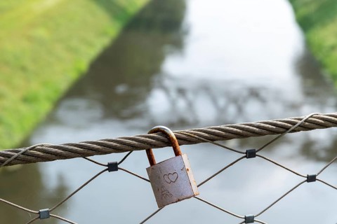Love lock on railing over sewer