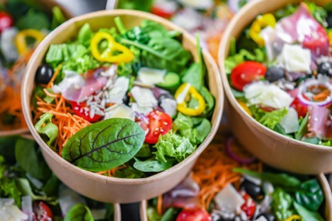 Round paper boxes with pre-packaged vegetable salads ready for sale