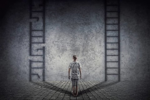 Person stands in front of a wall casting two ladder shadows with one broken on the left and another