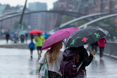 Symbolic picture weather, heavy rain in summer, thunderstorm, thunderstorm, tourists with umbrellas