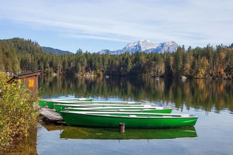 Mountain massif Hoher Göll with forest and boats at Hintersee in autumn, Ramsau, Berchtesgaden,