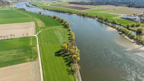 Greened bank areas with neighbouring fields and a meandering river (Danube) in a rural landscape,
