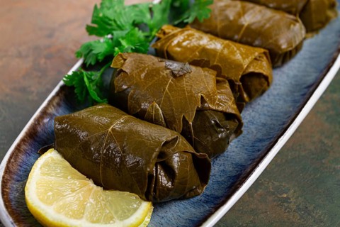 Dolma, minced meat with rice, in grape leaves, rolls with minced meat, on a plate, top view, no