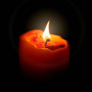 An image of a red candle in the dark