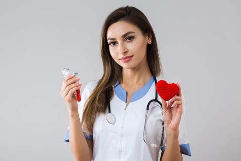 Beautiful woman holding plush heart blood sample